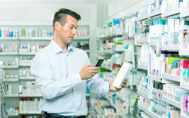 Pharmacist scanning a medicine pack with a mobile phone